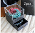 Gift box with artificial rose flower on top and drawer displaying blue beaded bracelets