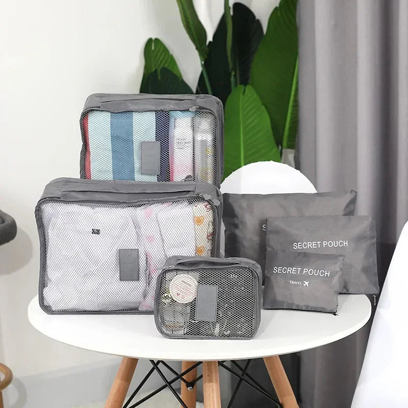Gray mesh travel organizer bags and pouches displayed on a white table for storage use