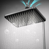 Modern square rainfall shower head with matte black finish, delivering high-pressure water spray.