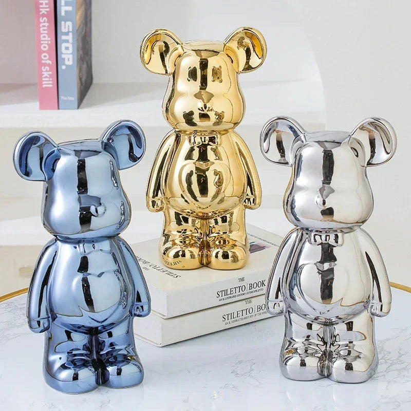 Trio of metallic bear-shaped figurines in gold, silver, and blue, glossy finish, modern decor