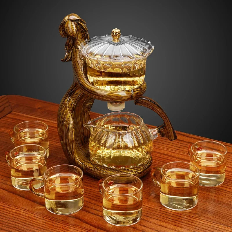 Elegant glass tea set with amber liquid, featuring six cups and a sculpted teapot on wood table.
