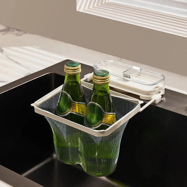 Mesh hanging sink organizer with two green glass bottles, plastic frame, modern kitchen