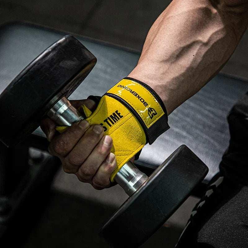 Man wearing yellow and black fitted workout gloves lifting a black dumbbell in gym.