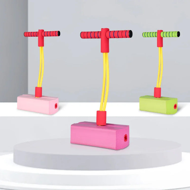 Foam pogo jumpers in pink and green with yellow bungee cords and red handles, displayed on podiums.