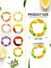 Assorted round fruit-themed plastic rings with bear-shaped cutouts, colorful design, small size.