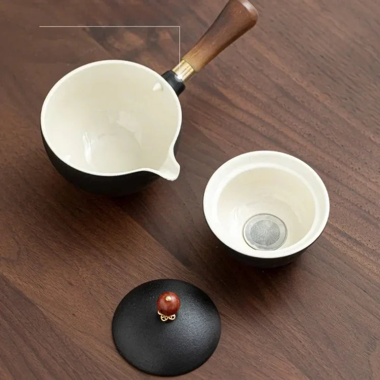Modern black and white ceramic tea set with wood handle and strainer, minimalist style