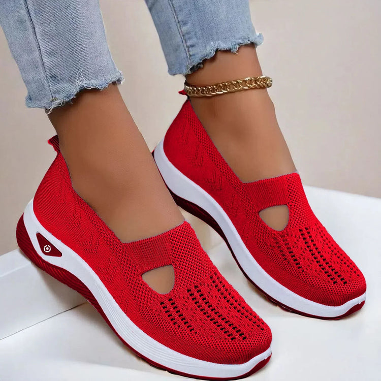 Red knit slip-on sneakers with breathable mesh upper, white sole, casual fit, and cutout design.