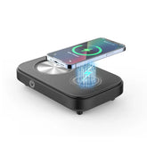 Black wireless charging pad with smartphone, modern tech accessory on white background