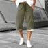 Man wearing olive green knee-length drawstring shorts with relaxed fit and white trim, casual streetwear style.