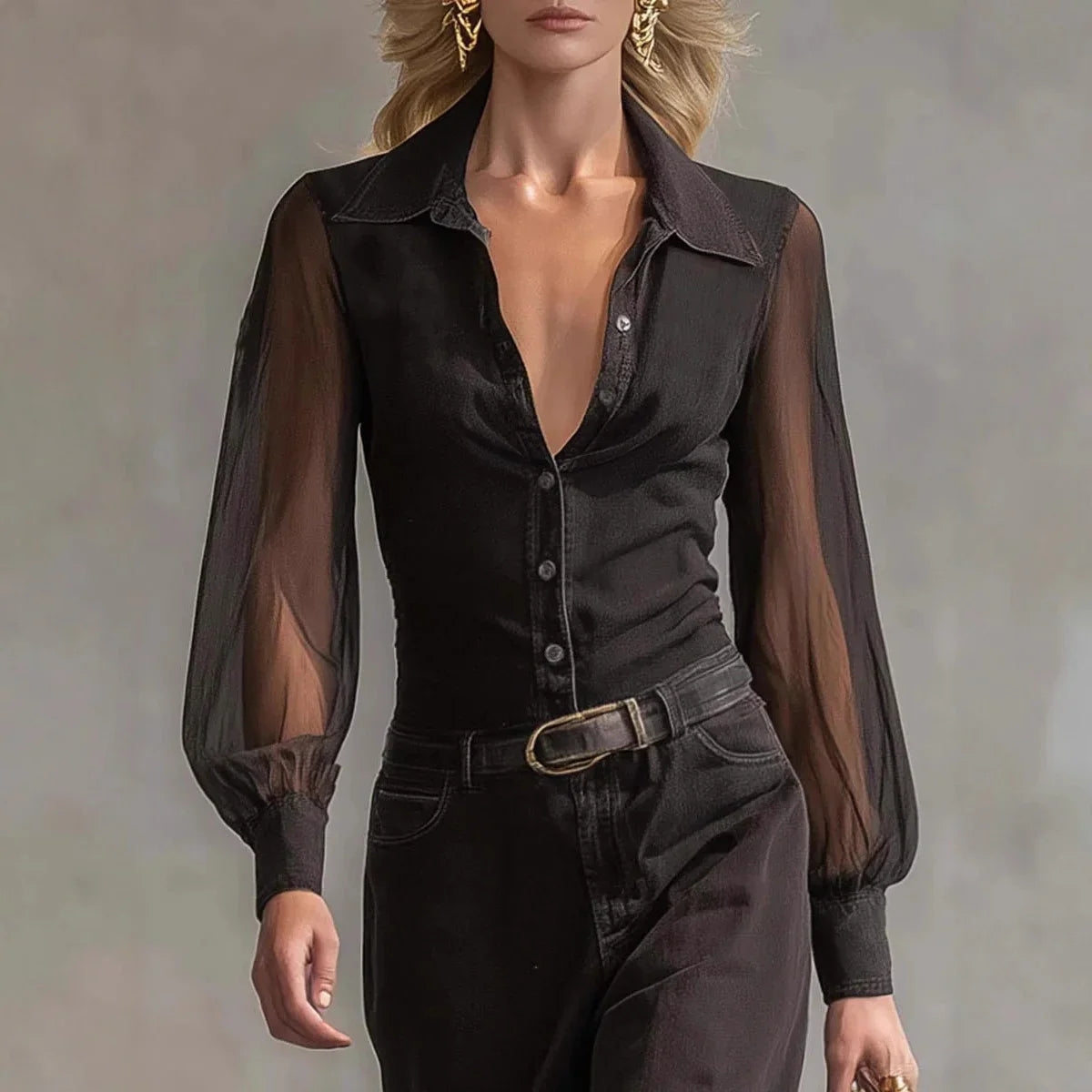 Woman wearing a sheer black long sleeve blouse and high-waisted black pants with a belt