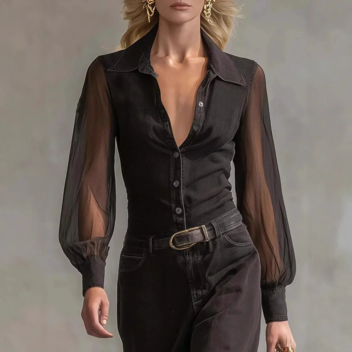 Woman wearing a sheer black long sleeve blouse and high-waisted black pants with a belt