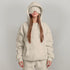 Woman in oversized beige hoodie and sweatpants with relaxed fit and matching eye mask