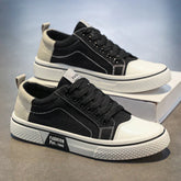 Black and beige canvas sneakers with white rubber soles and lace-up closure, casual streetwear style.