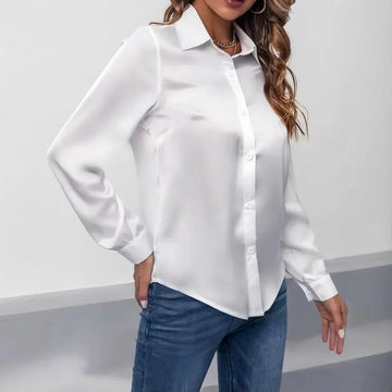 Woman wearing white long sleeve button-up blouse with collar, paired with blue jeans