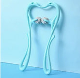 Light blue handheld massage roller with dual spiked wheels on pastel blue background