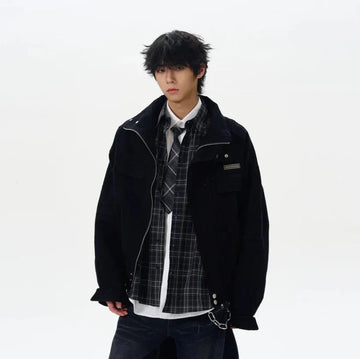 Man wearing oversized black jacket, plaid shirt, tie, and dark jeans, streetwear style