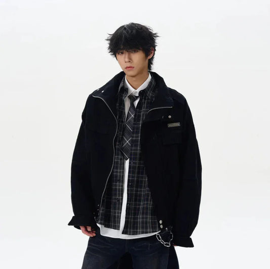 Man wearing oversized black jacket, plaid shirt, tie, and dark jeans, streetwear style