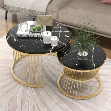 Modern black marble round coffee tables with gold metal frames on a light patterned rug