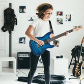Woman wearing a white cotton t-shirt and slim black jeans, playing guitar in a modern room