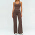 Woman wearing brown fitted tank top and flared pants set with white trim, sporty style.
