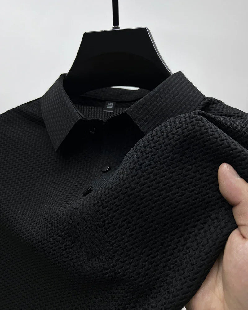 Black textured long sleeve shirt with button front and relaxed fit, held on hanger