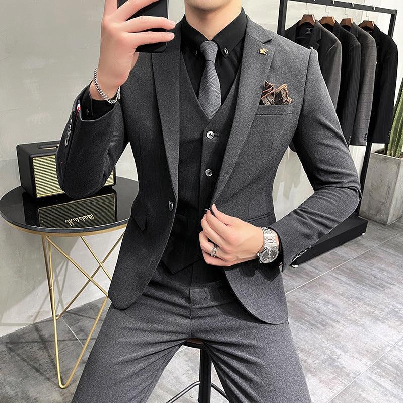 Slim fit gray suit with matching vest, black shirt, and gray tie; modern streetwear style.