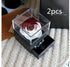 Red and white preserved rose in clear display box with jewelry drawer, on knitted surface
