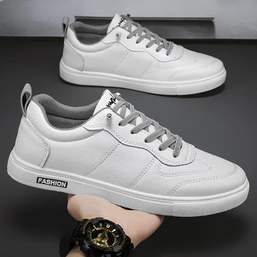 White low-top sneakers with gray laces, faux leather material, and modern streetwear style.
