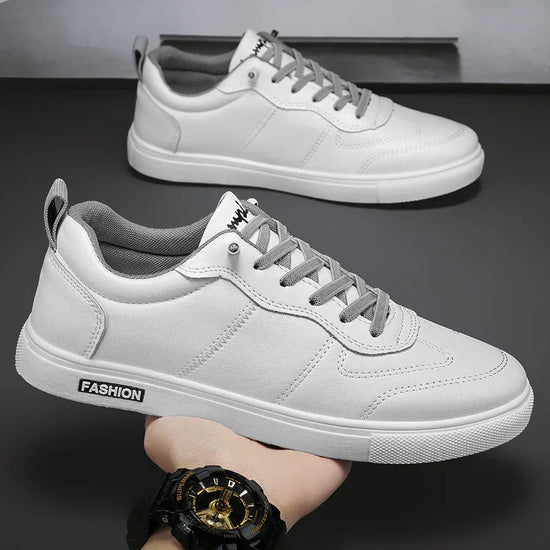 White low-top sneakers with gray laces, faux leather material, and modern streetwear style.