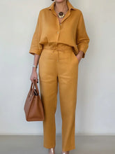 Woman in loose-fit mustard yellow button-up shirt and drawstring pants, holding brown tote bag