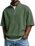 Man wearing loose fit green waffle knit short sleeve pullover with half zip, blue jeans