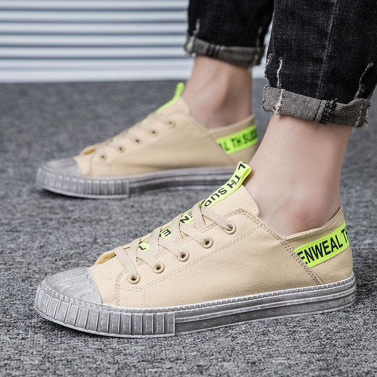 Beige low-top canvas sneakers with neon yellow accents and text, casual streetwear style