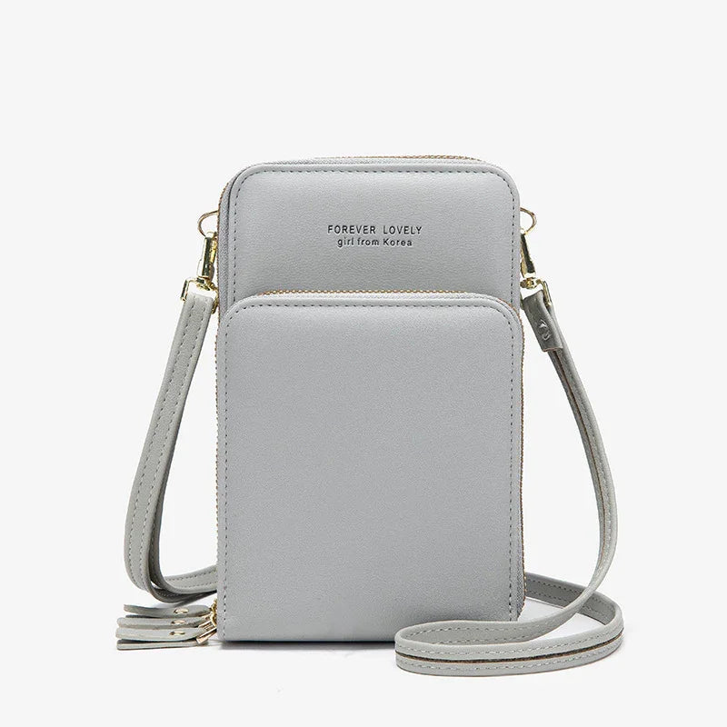 Light grey faux leather crossbody bag with adjustable strap and zip closure, minimalist design