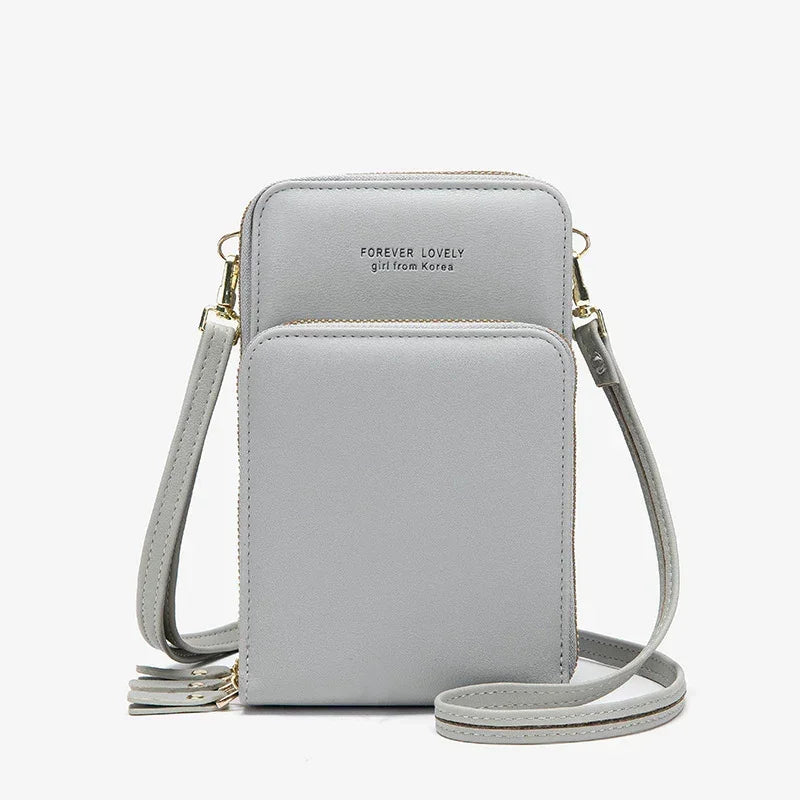 Light grey faux leather crossbody bag with adjustable strap and zip closure, minimalist design
