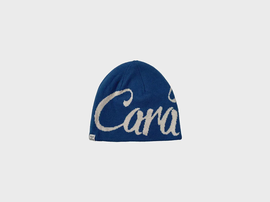 Blue knit beanie with bold white script, soft material, relaxed streetwear fit