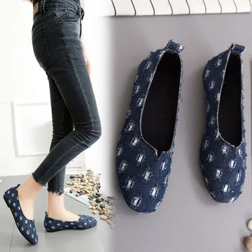 Casual blue denim slip-on flats with distressed pattern, paired with skinny jeans