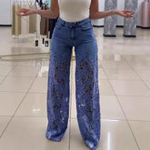 Woman wearing blue wide-leg denim pants with sheer lace floral panels and a fitted white tank top