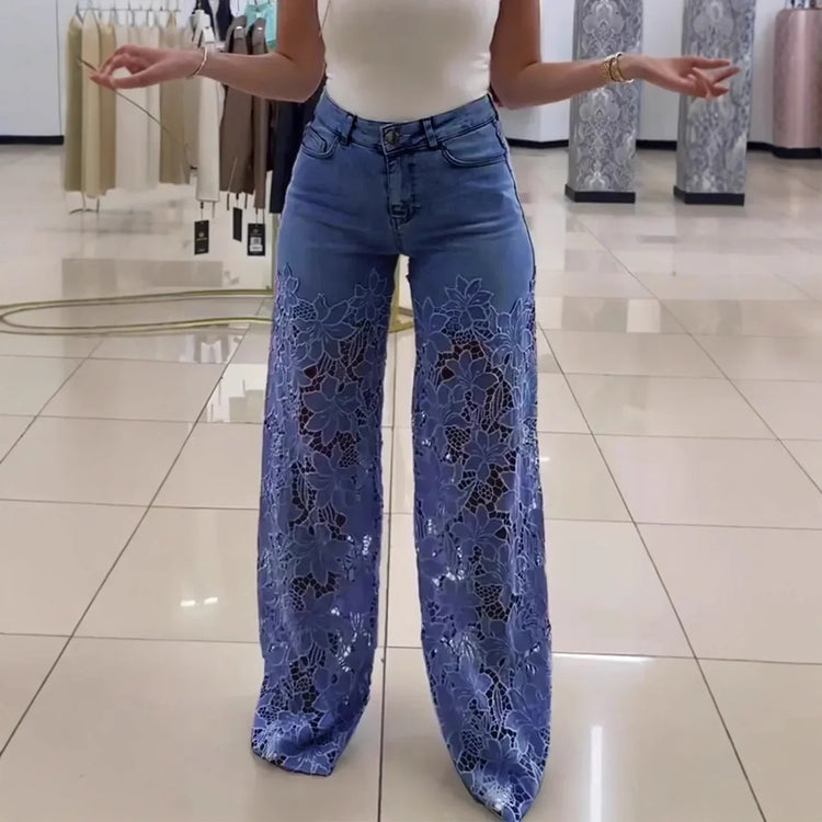 Woman wearing blue wide-leg denim pants with sheer lace floral panels and a fitted white tank top