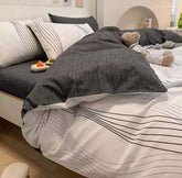 Cotton gradient color bed sheet set with dark and light striped design on a neatly made bed