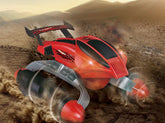 Futuristic red remote control car with large wheels driving on sandy terrain