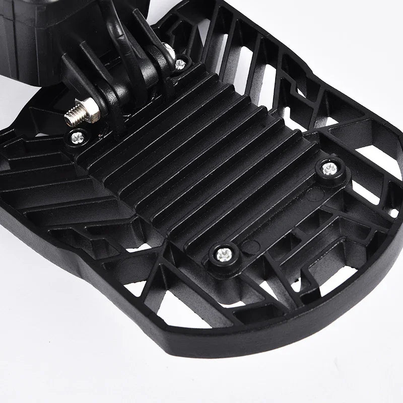 Close-up of black plastic textured accessory with geometric cutouts and screws