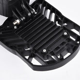 Close-up of black plastic textured accessory with geometric cutouts and screws