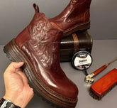 Chunky brown leather Chelsea boots with round toe and platform sole, featuring a glossy finish.