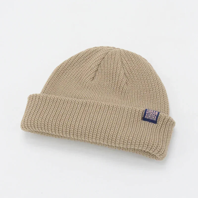 Beige ribbed knit beanie with cuff, minimalist streetwear style and relaxed fit
