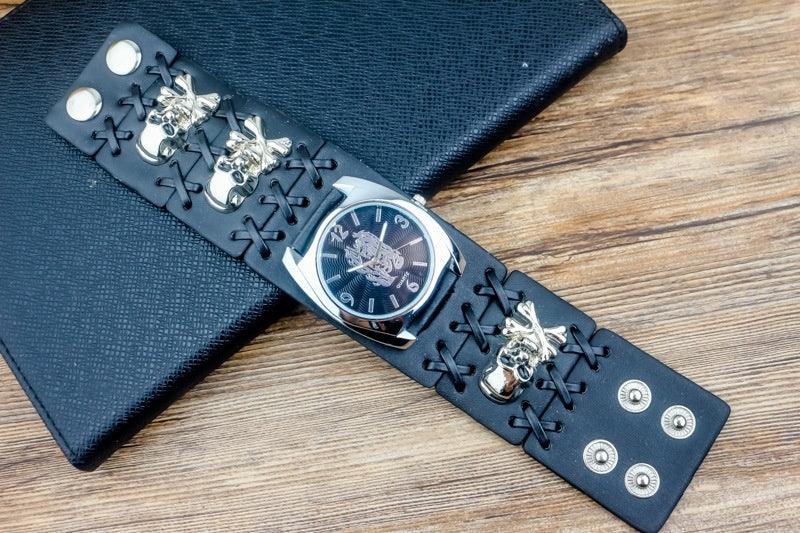 Black leather wide strap watch with metal skull accents, lace-up details, and snap closures