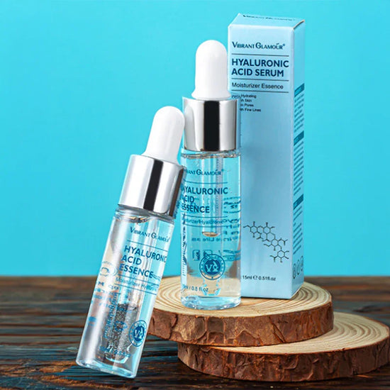 Clear liquid serum in glass dropper bottles with silver caps on wooden display, blue background.
