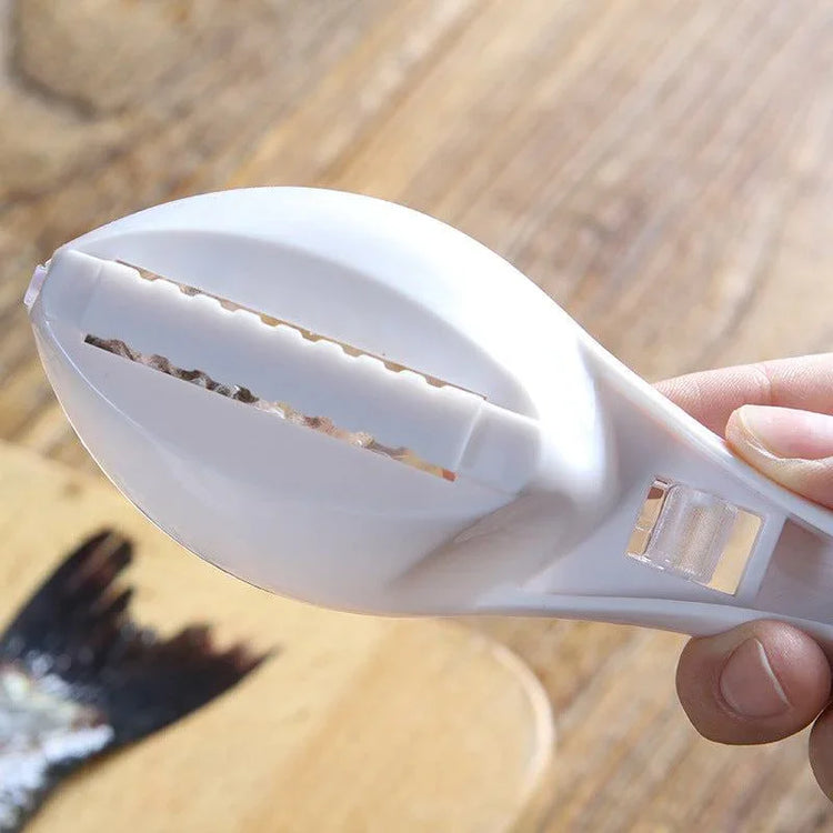 White plastic fish scaler tool with serrated blade and ergonomic handle on wooden surface