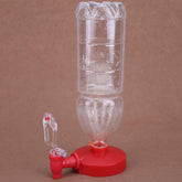 Clear plastic bottle with red base and spout, used as a water dispenser, on brown background.