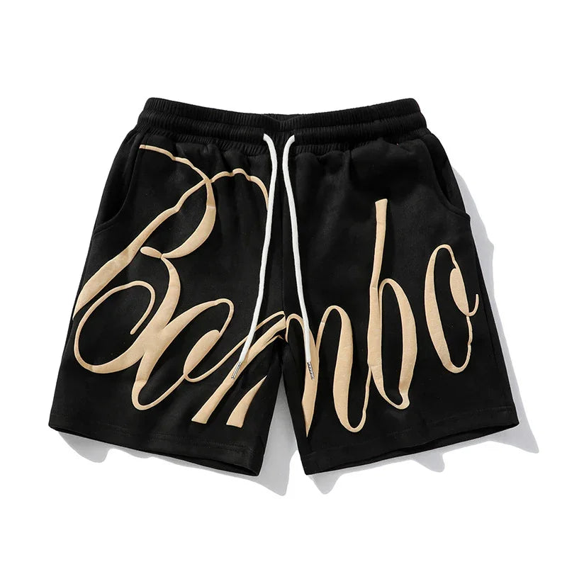 Black streetwear shorts with beige graffiti script, elastic waistband, and relaxed fit