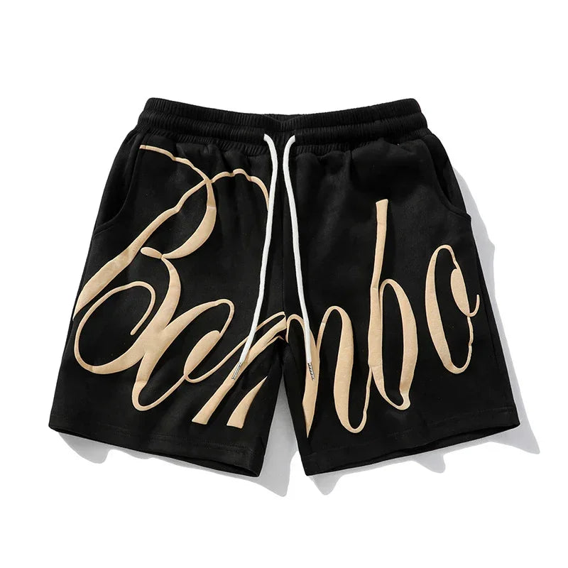 Black streetwear shorts with beige graffiti script, elastic waistband, and relaxed fit